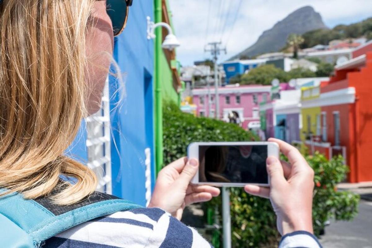 una donna che scatta una foto di una città con il suo cellulare