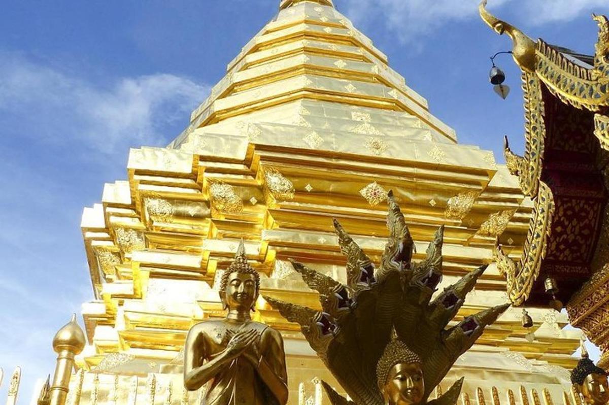 una pagoda dorata con una statua di fronte