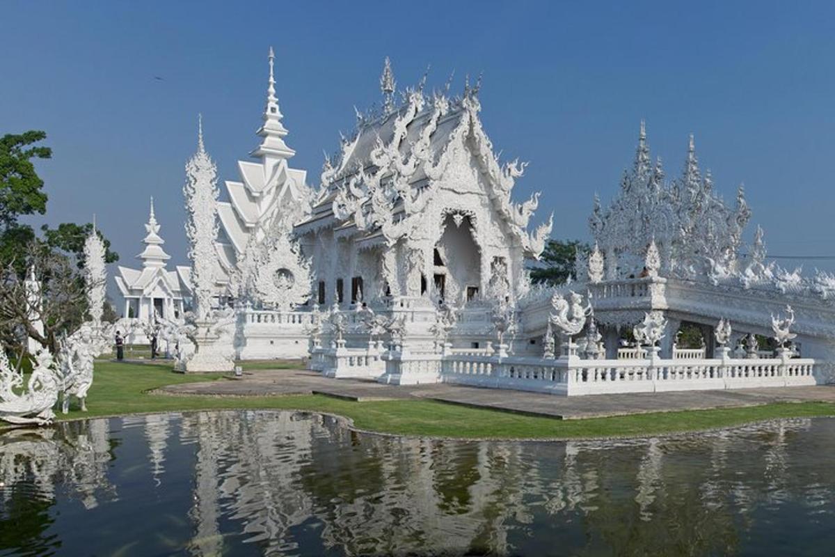 một tòa nhà màu trắng phản chiếu trên mặt nước