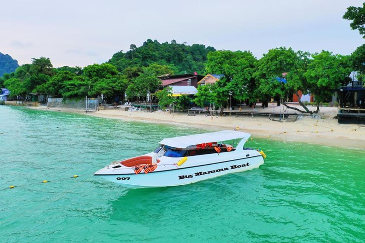 um barco branco na água ao lado de uma praia