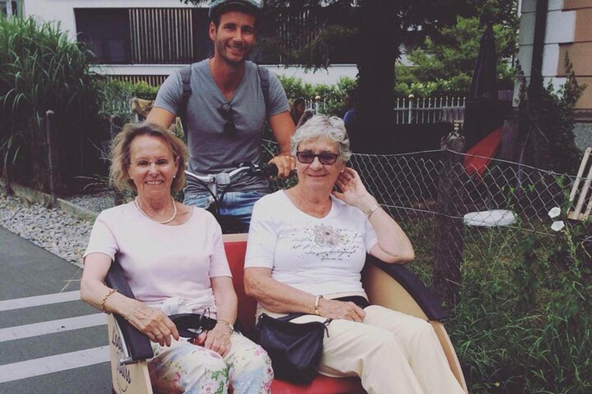 dve starejši ženski sedita na klopi z moškim