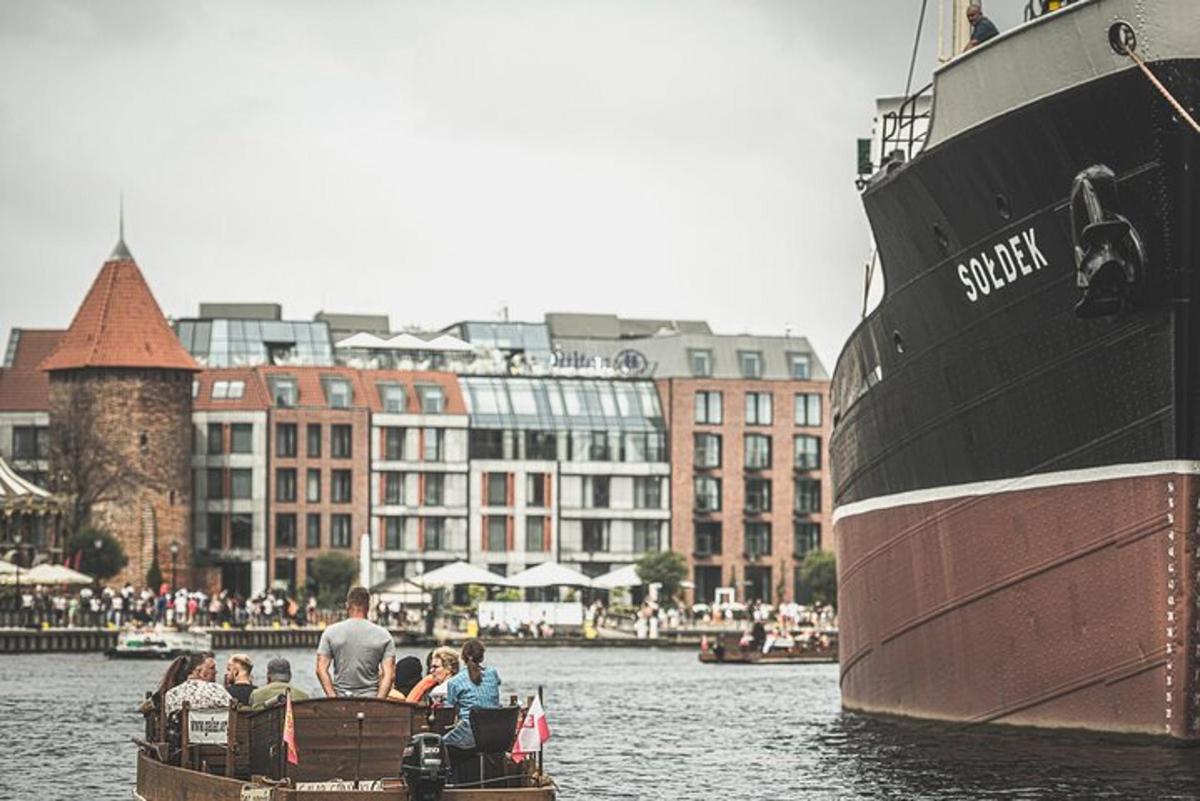 a group of people in a small boat in the water next to a ship