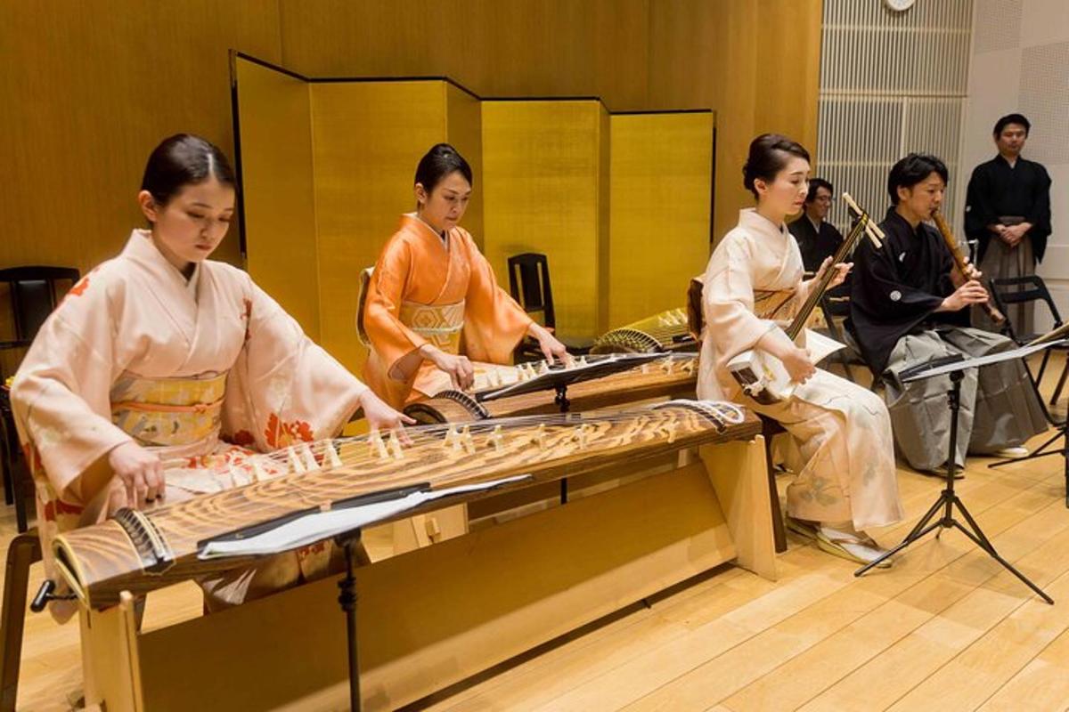 un grup de persones assegudes al voltant d'una taula amb instruments