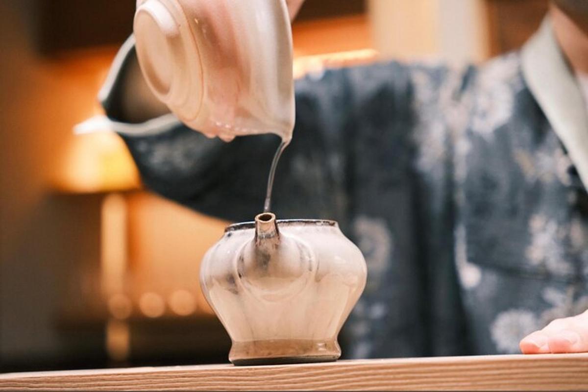 a person is pouring clay into a vase