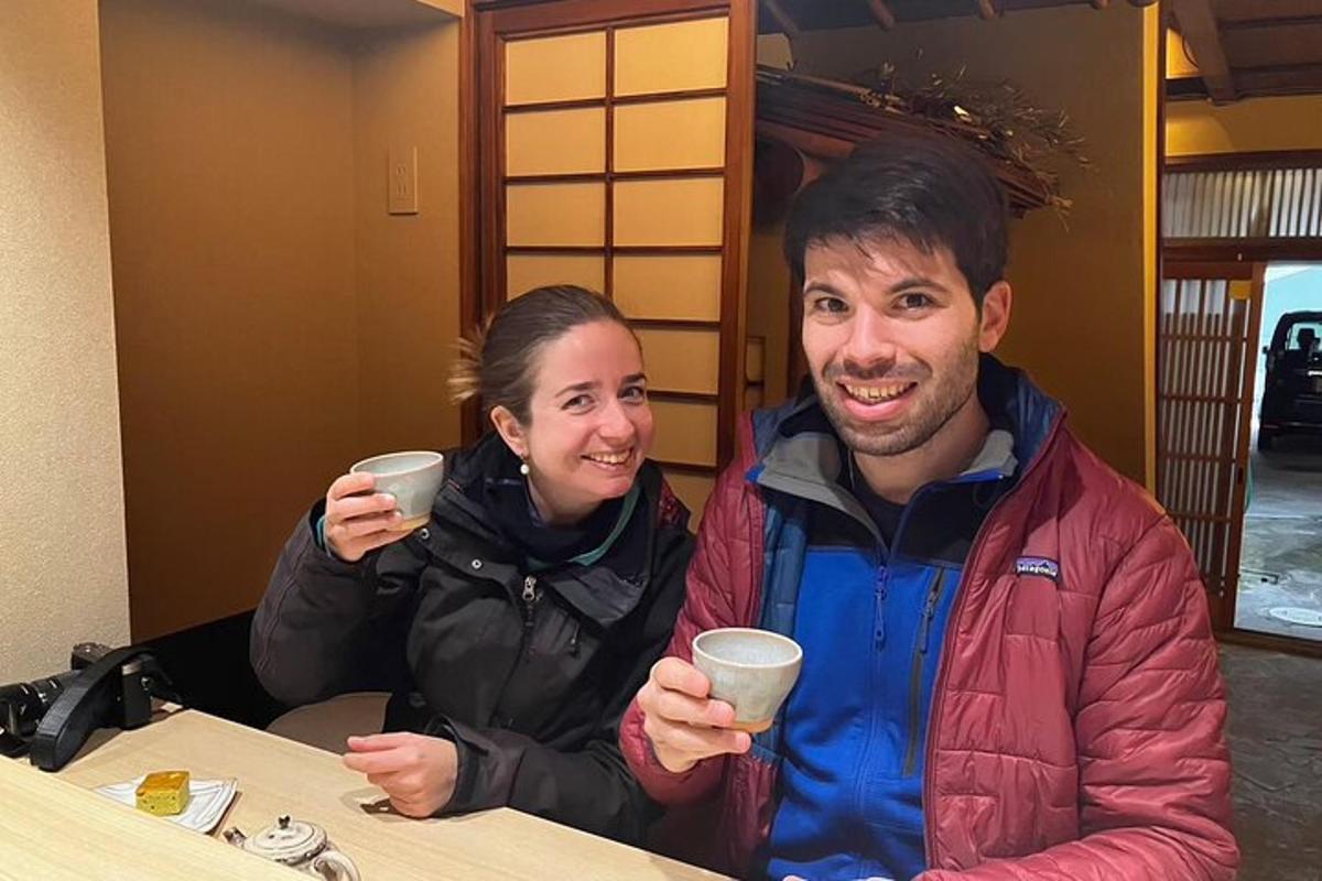 a man and a woman sitting at a table holding cups
