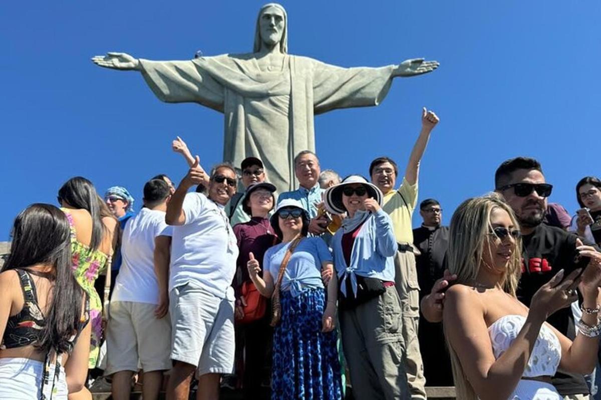 a group of people standing in front of the statue of christ the redeemer