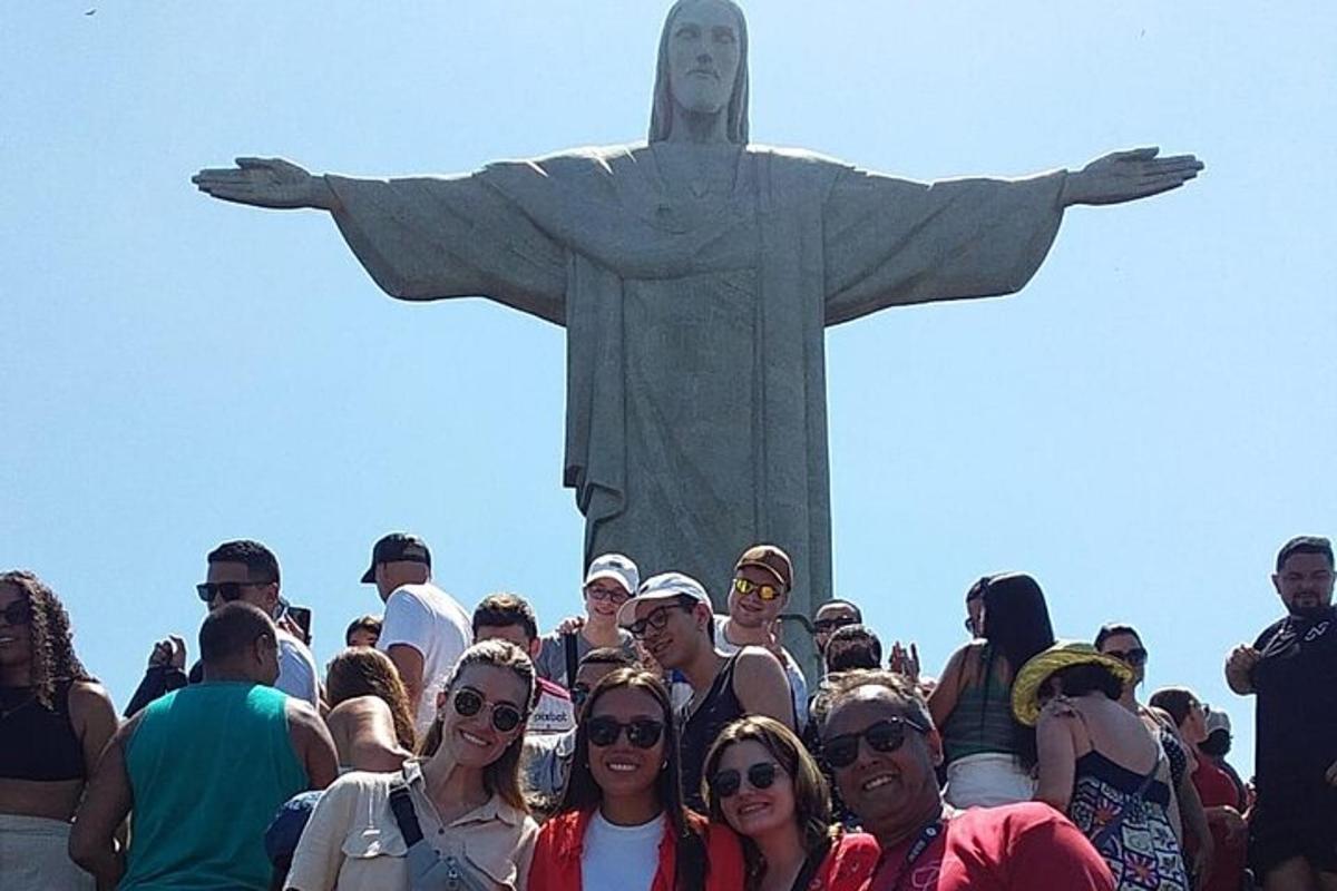 a group of people standing in front of the christ the redeemer statue
