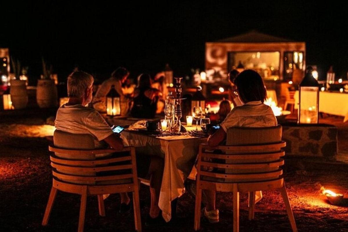 a group of people sitting at a table at night