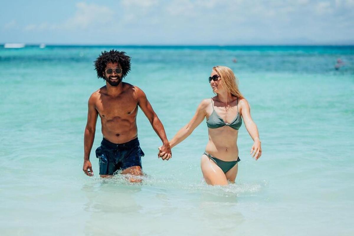 un uomo e una donna che camminano nell'acqua sulla spiaggia