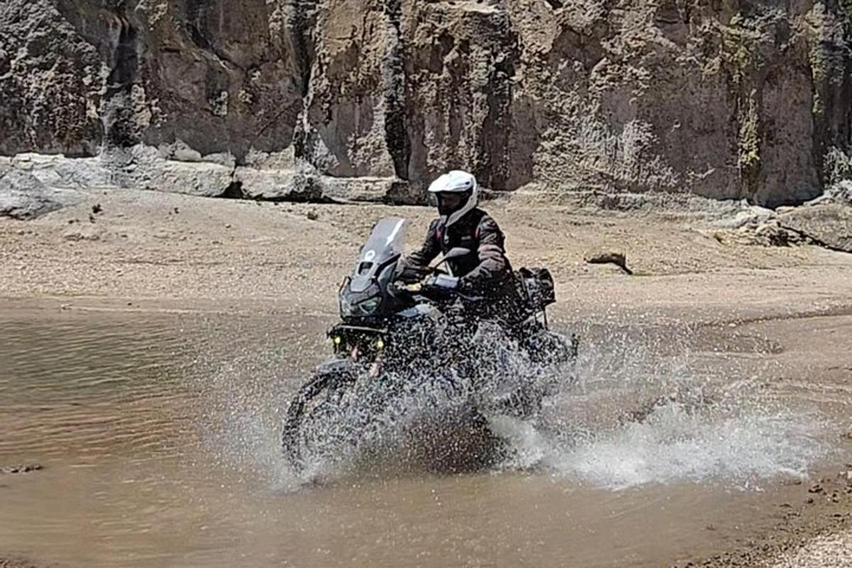 a person riding a motorcycle through the water