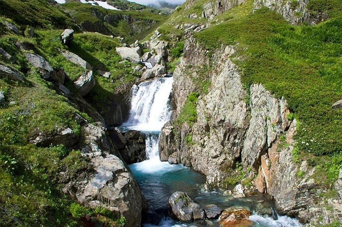 una cascada en la ladera de una montaña rocosa