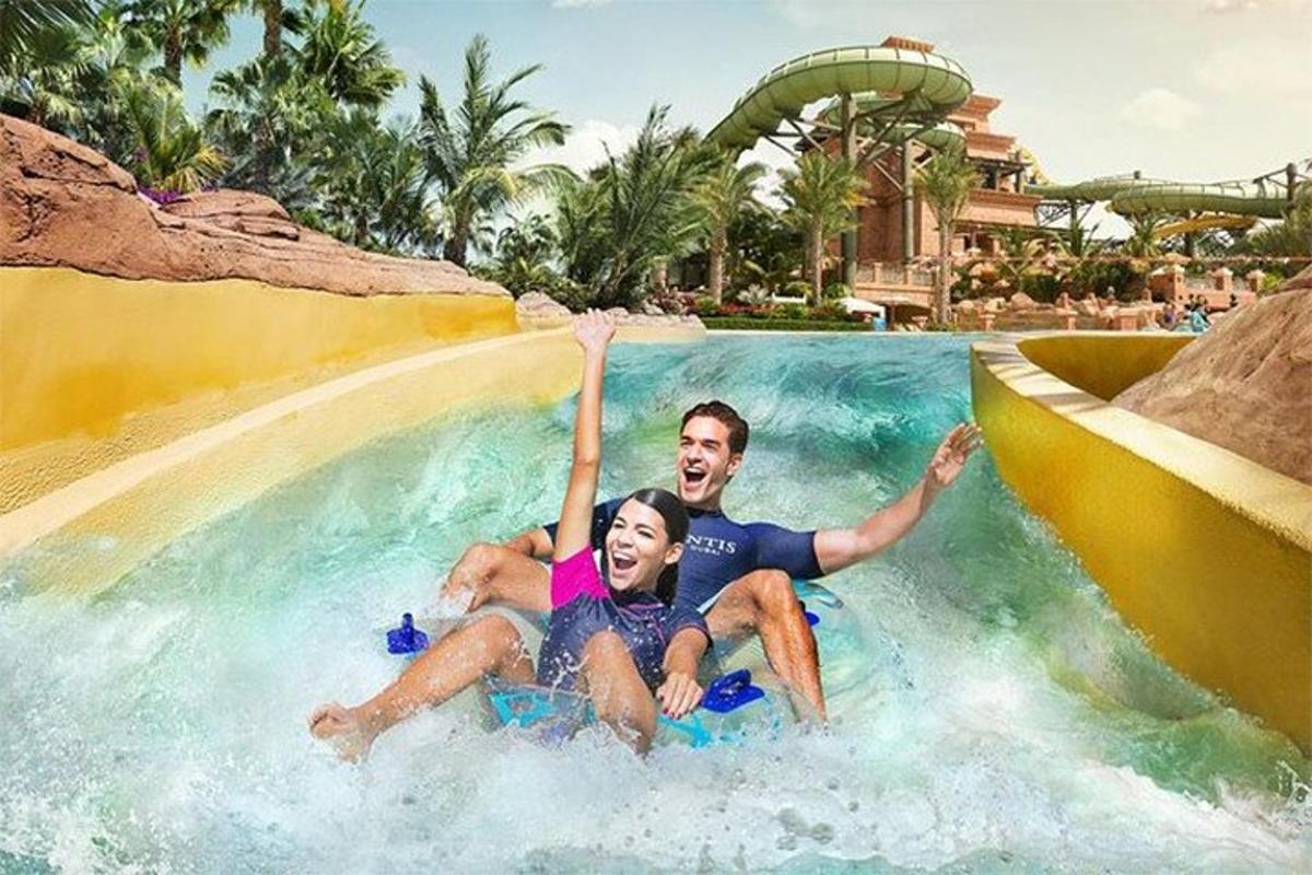 a man and woman riding a wave pool at a resort