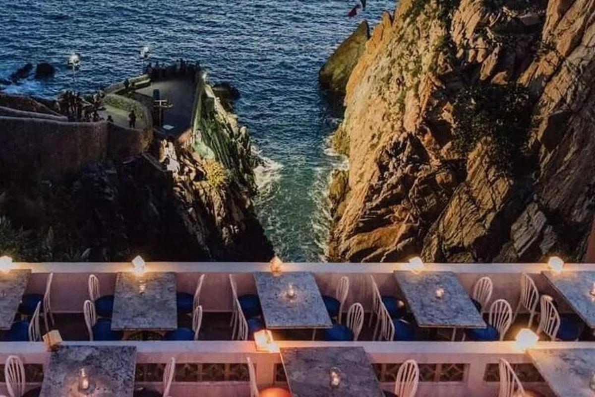 a view of the ocean from a restaurant with tables and chairs
