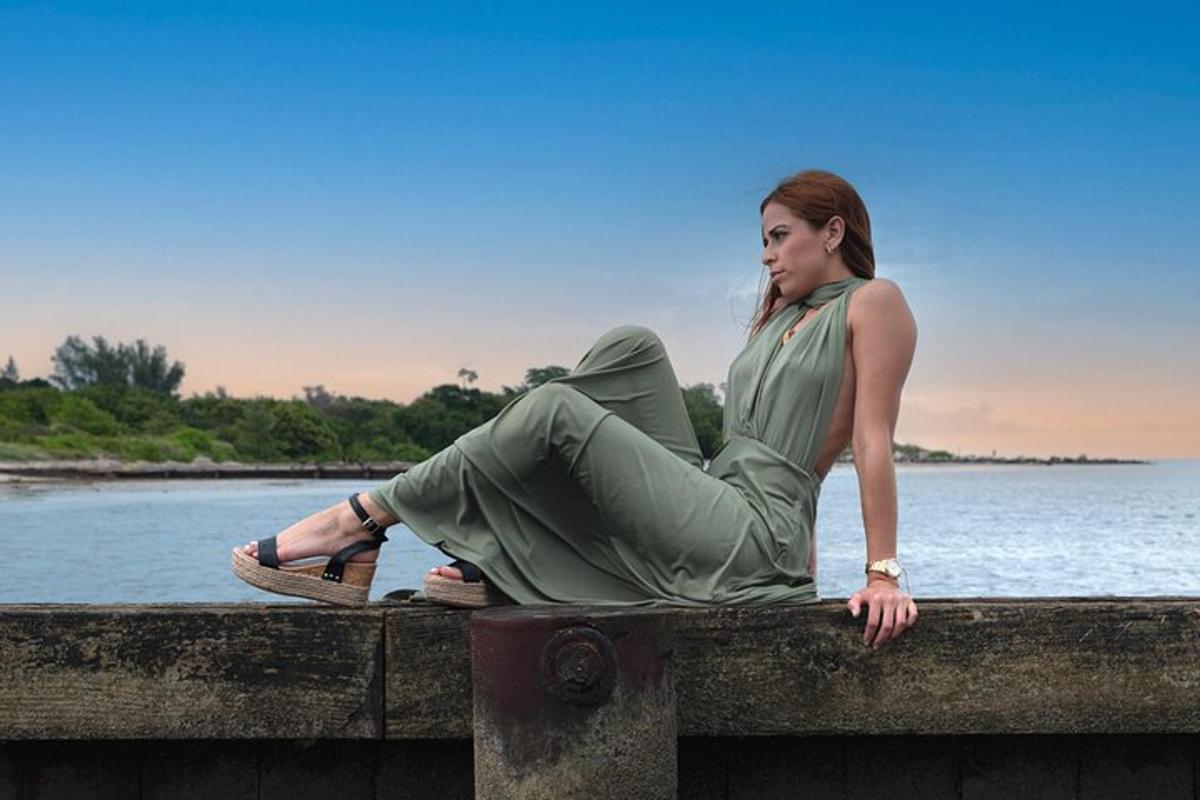 una mujer sentada en un puente cerca del agua