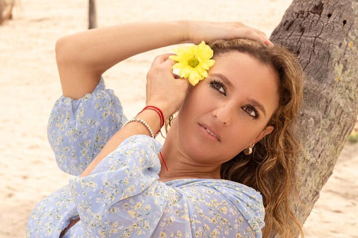 una donna con un fiore giallo in testa accanto a un albero
