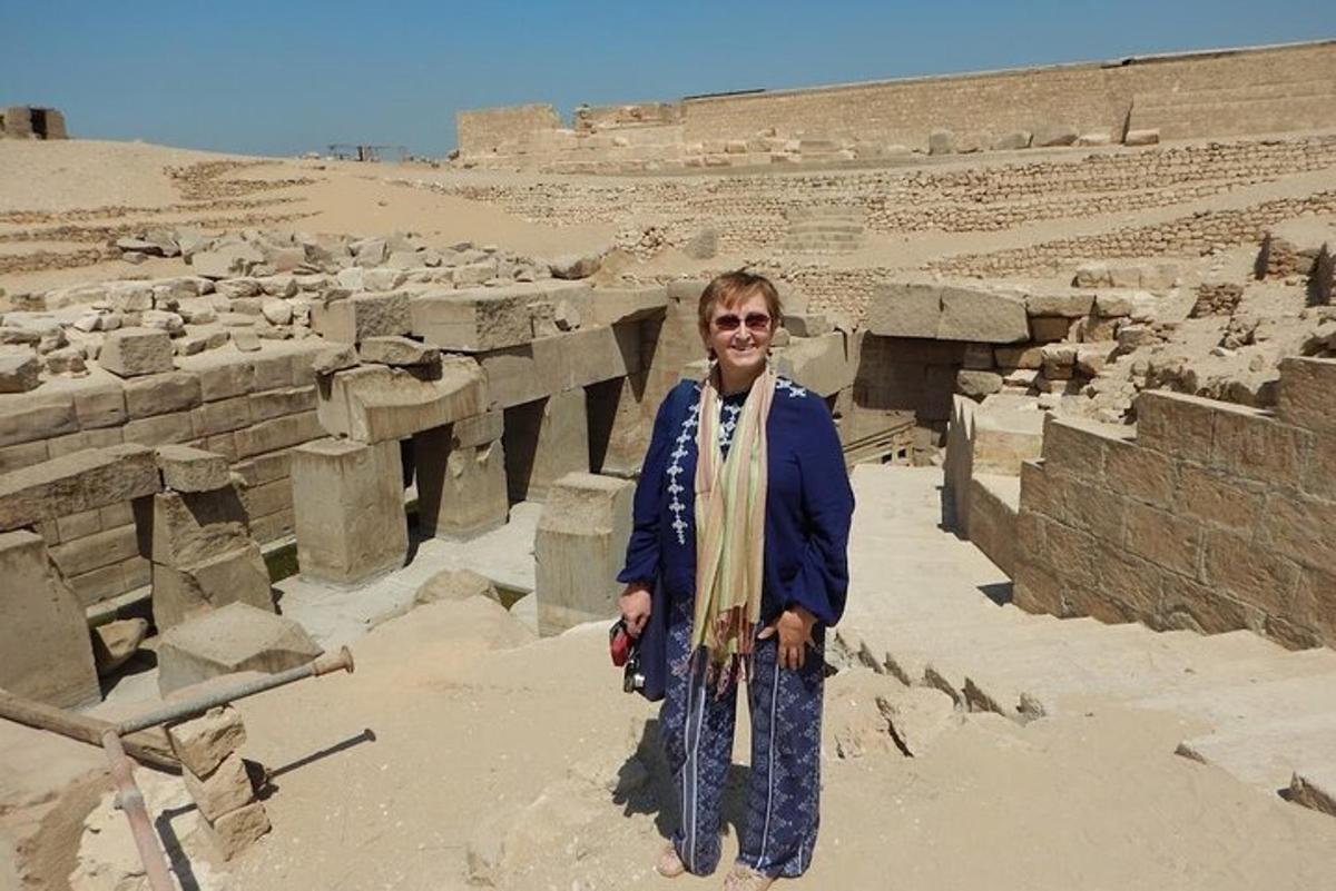 una donna è in piedi davanti a delle rovine