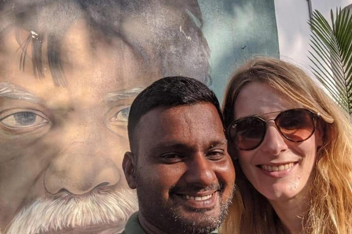 a man and a woman standing in front of a painting