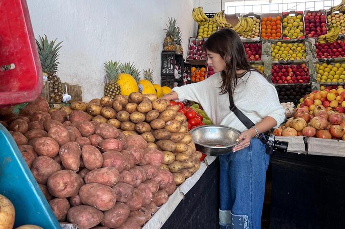 žena stojící na trhu s hrozen ovoce