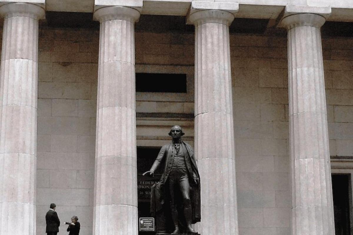 una statua di un uomo in piedi davanti a un edificio
