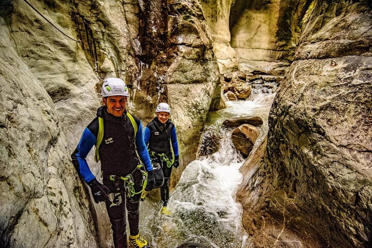deux personnes se tiennent dans une cascade dans un canyon