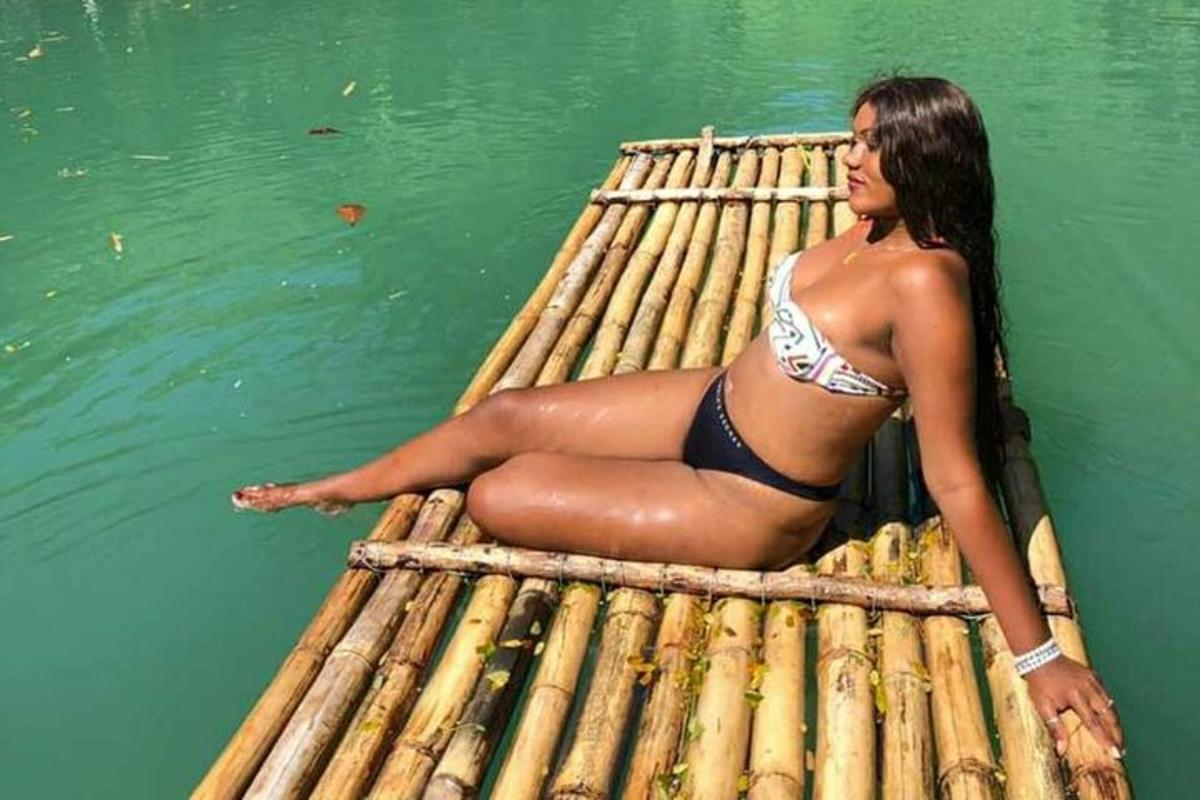una donna in bikini sdraiata su una zattera in acqua