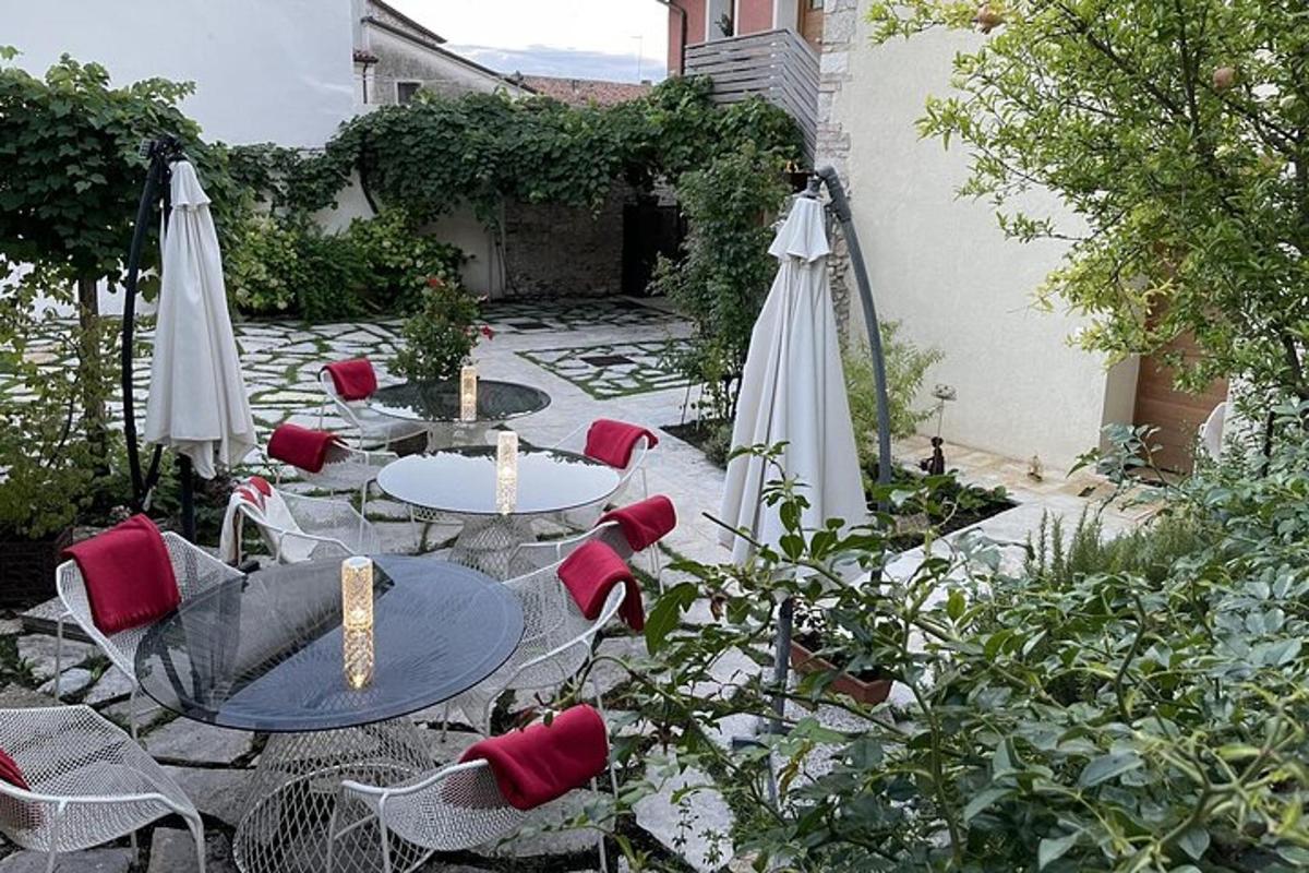 un patio esterno con tavoli, sedie e ombrelloni