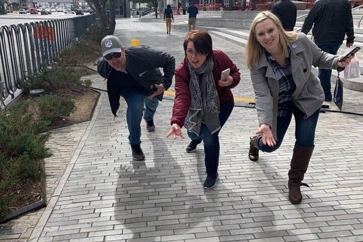 a man and two women running down a sidewalk