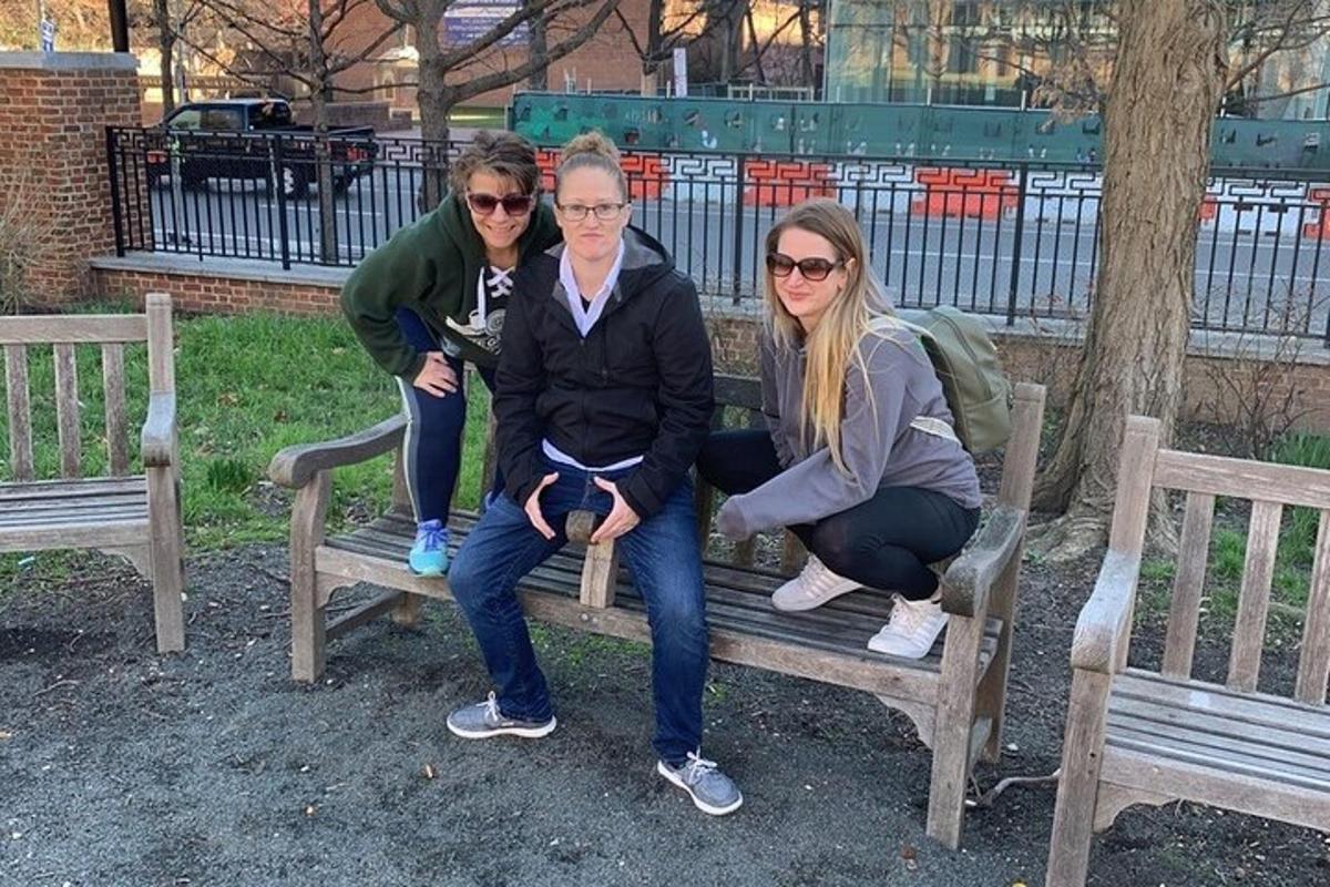 three women are sitting on a park bench