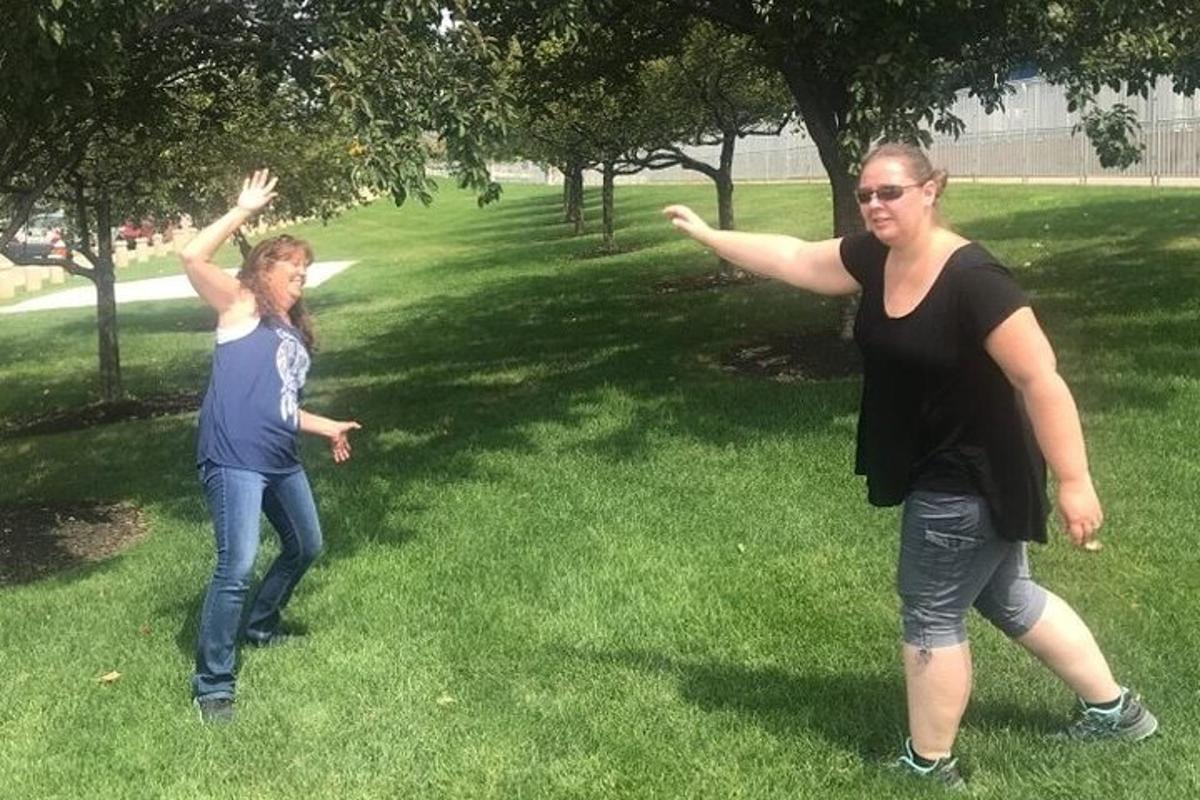 two girls playing with a frisbee in a park