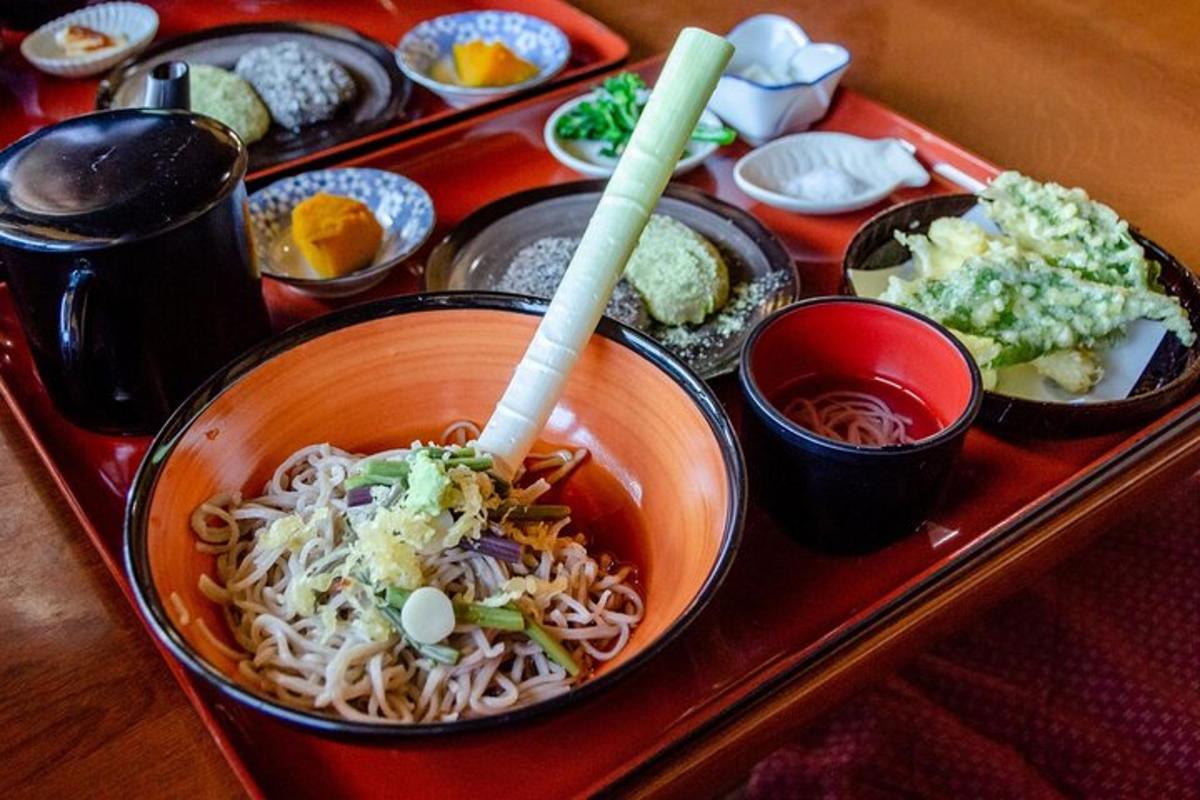 a bowl of noodles on a tray with other dishes