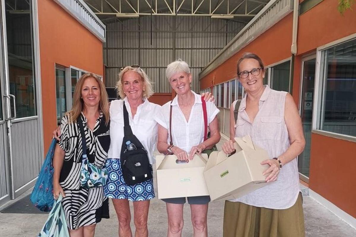 um grupo de mulheres em pé ao lado de um prédio segurando caixas