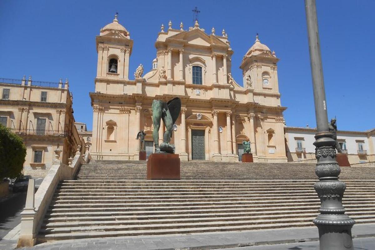 un edificio con scale di fronte a un edificio con una statua
