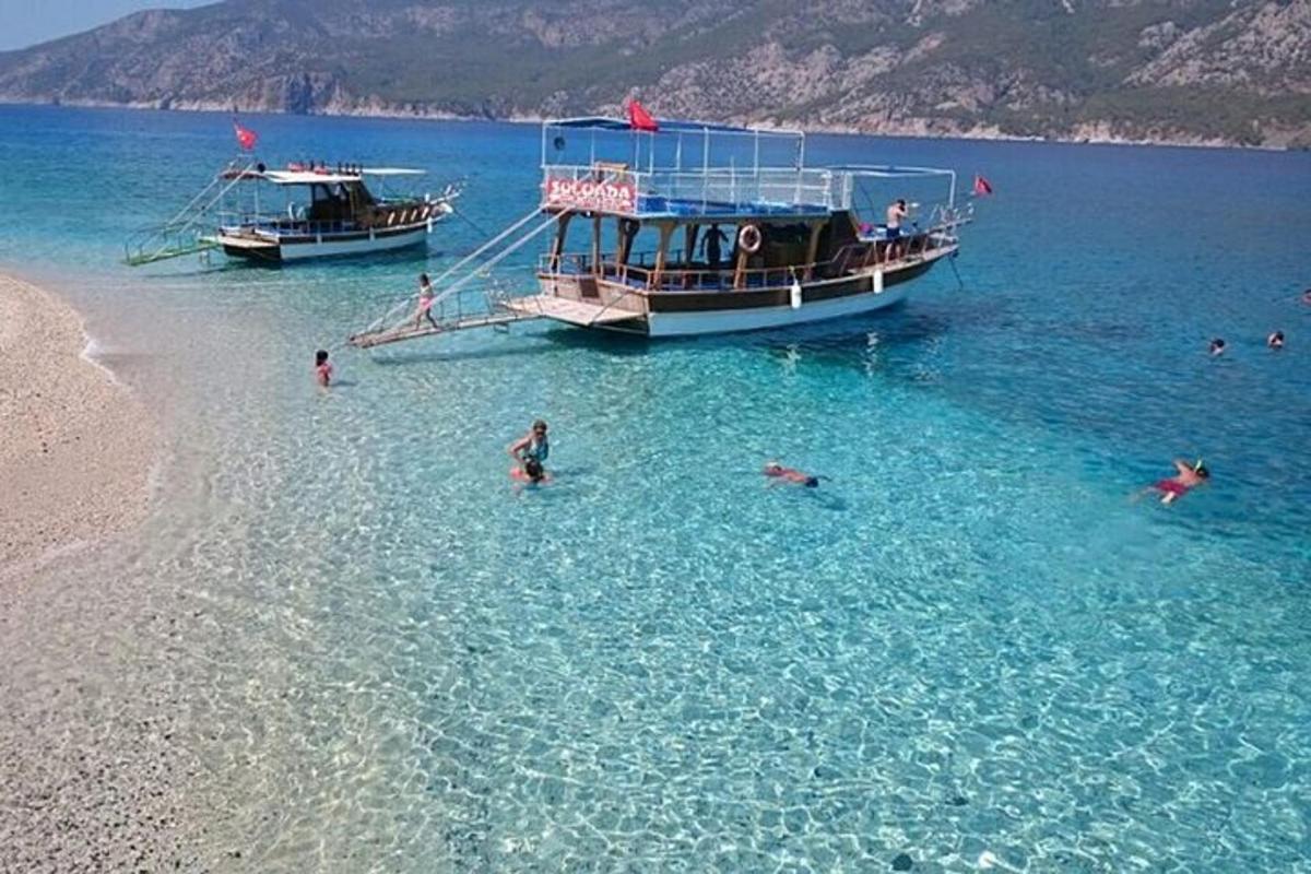กลุ่มคนกำลังว่ายน้ำอยู่ข้างเรือ