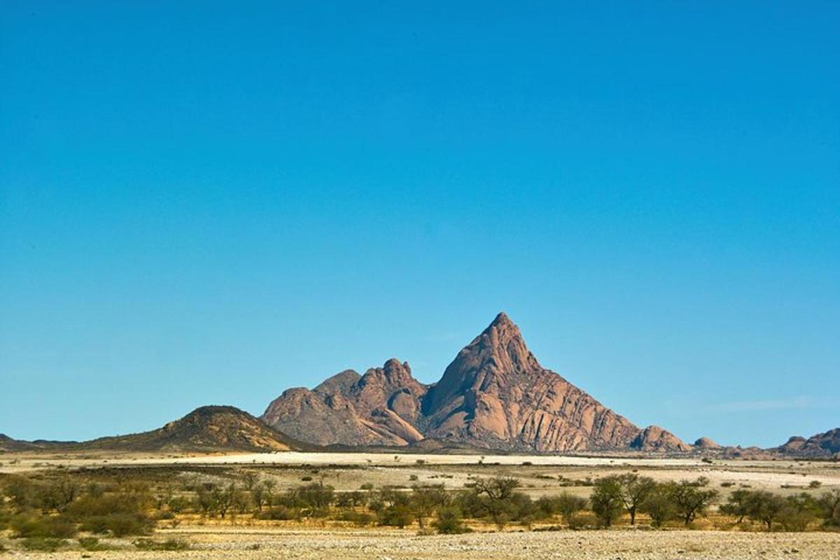 a mountain in the desert under a blue sky