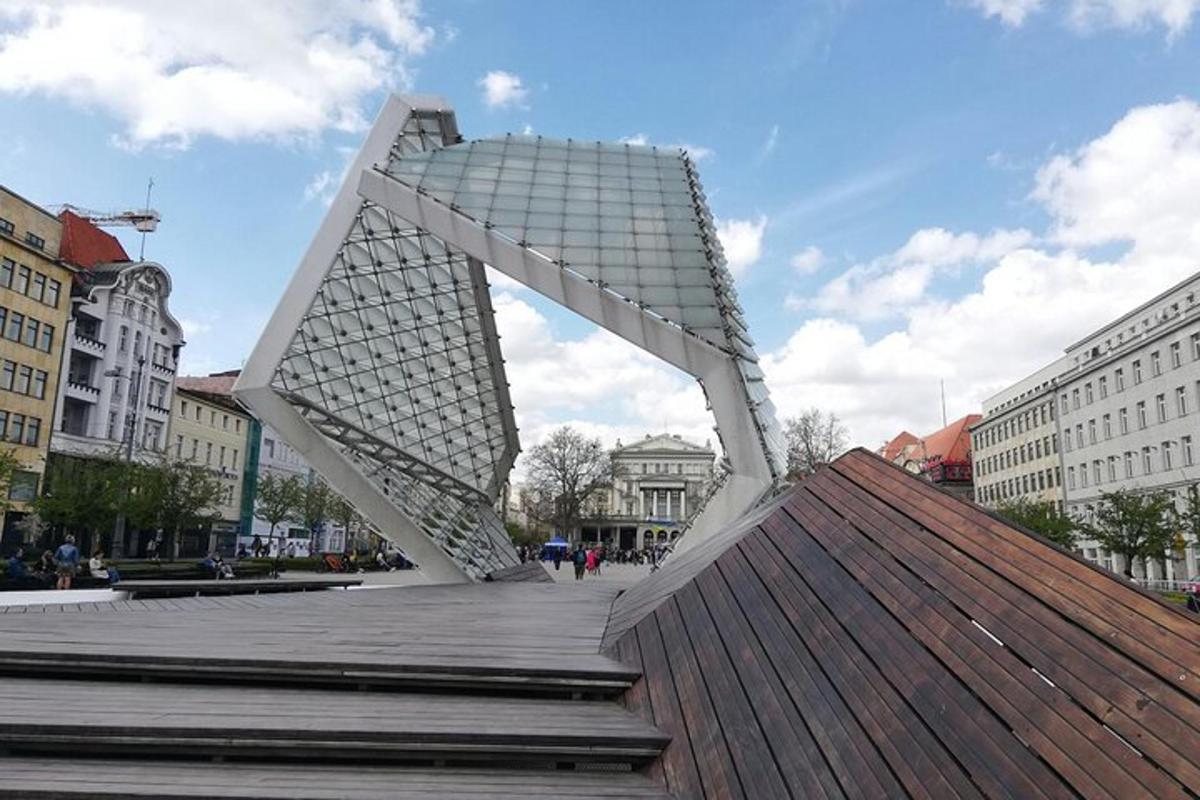 eine große weiße Skulptur auf einer Promenade in einer Stadt