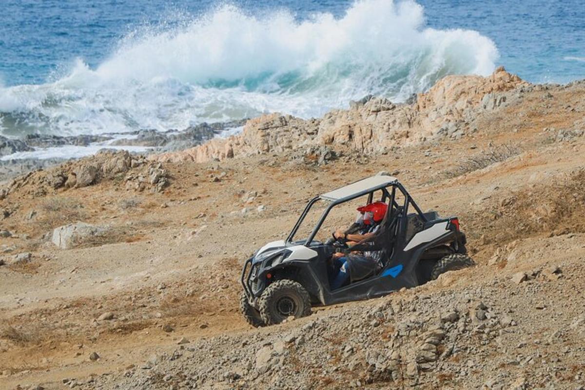 una persona che guida un quad su una collina sterrata