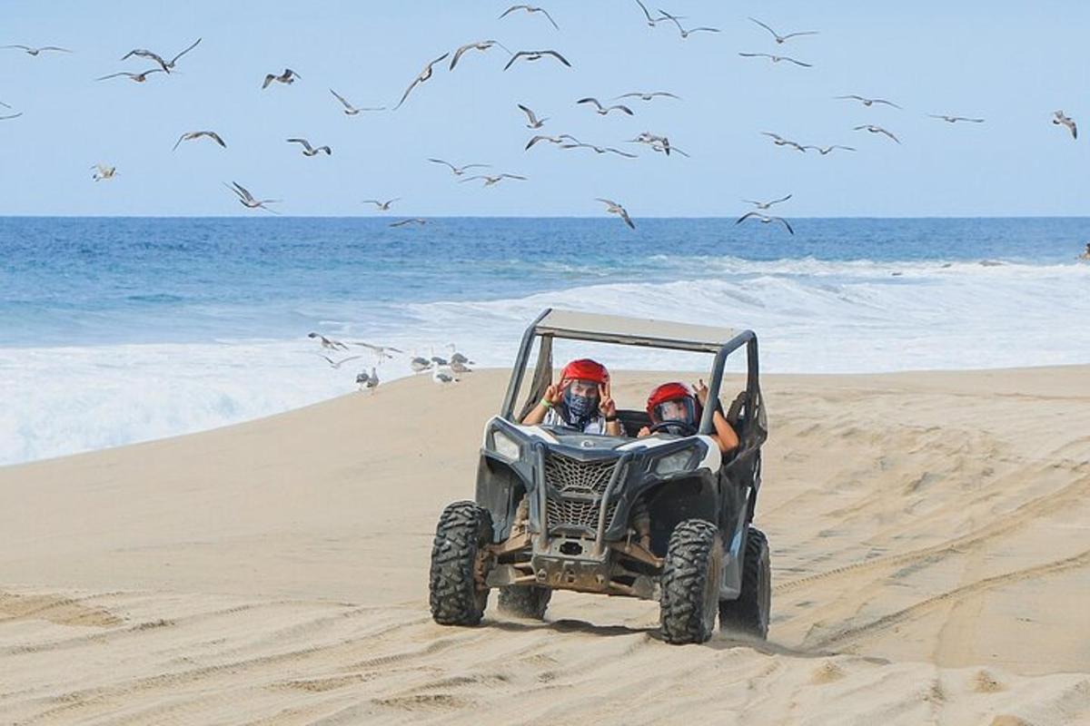 due persone in un quad sulla spiaggia