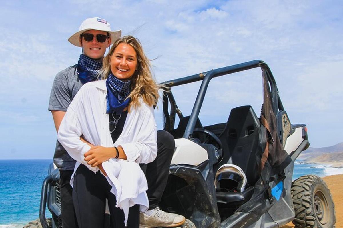 un uomo e una donna seduti in una jeep sulla spiaggia