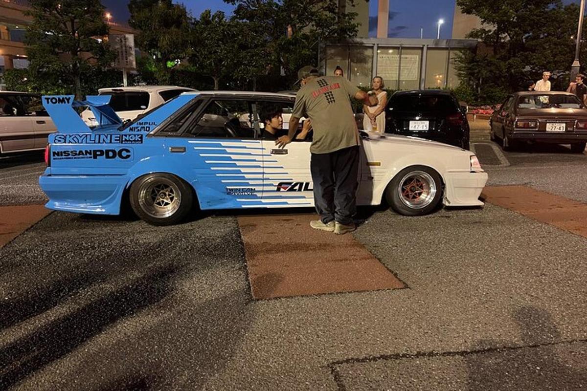 un hombre de pie junto a un coche de carreras