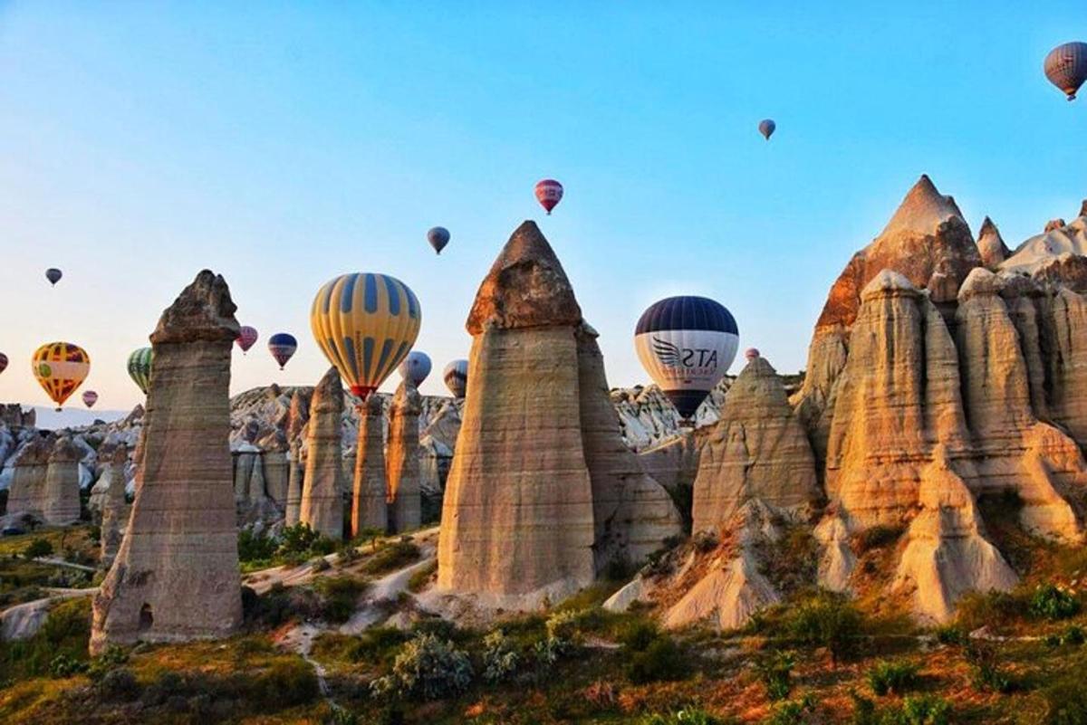 un gruppo di mongolfiere che volano sopra alcune rocce