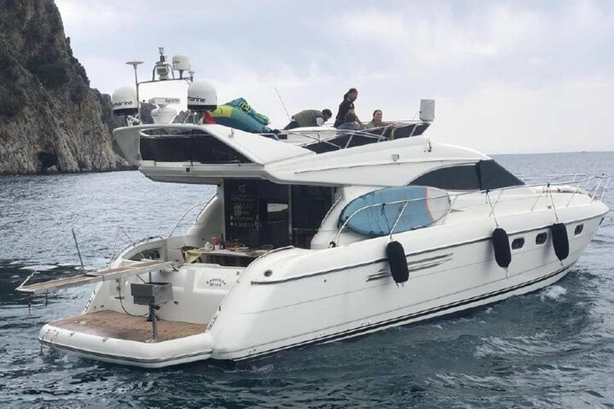 a white boat in the water with people on it