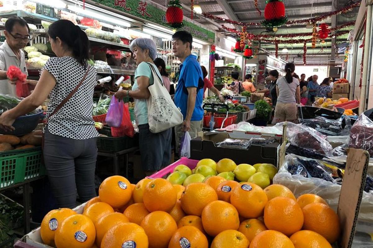 một nhóm người ở chợ bán cam và táo