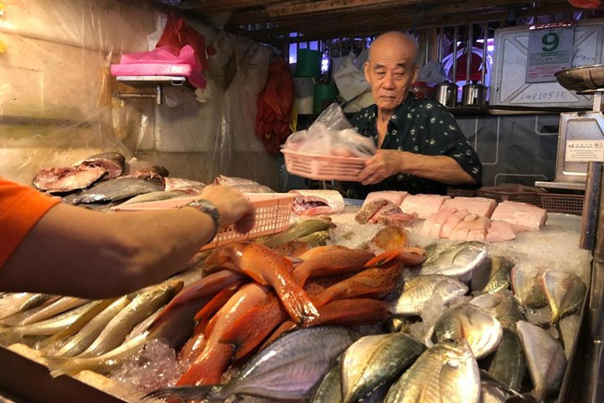 một người đàn ông đứng trước chợ bán cá