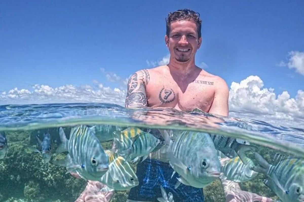 a man is standing in the water with fish
