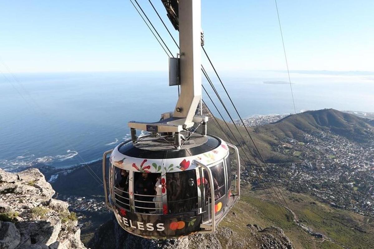 bir şehrin bulunduğu dağın üzerinden uçan bir teleferik