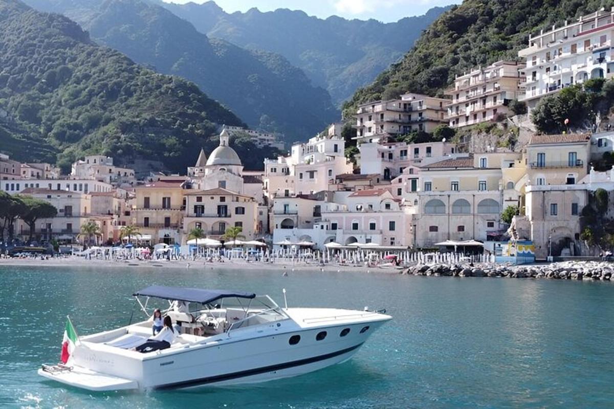 Un barco blanco en el agua frente a un pueblo.