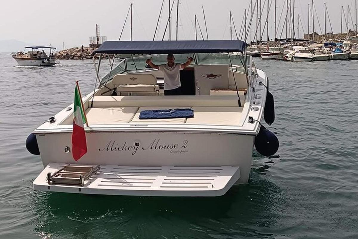 Un hombre parado en un bote blanco en el agua