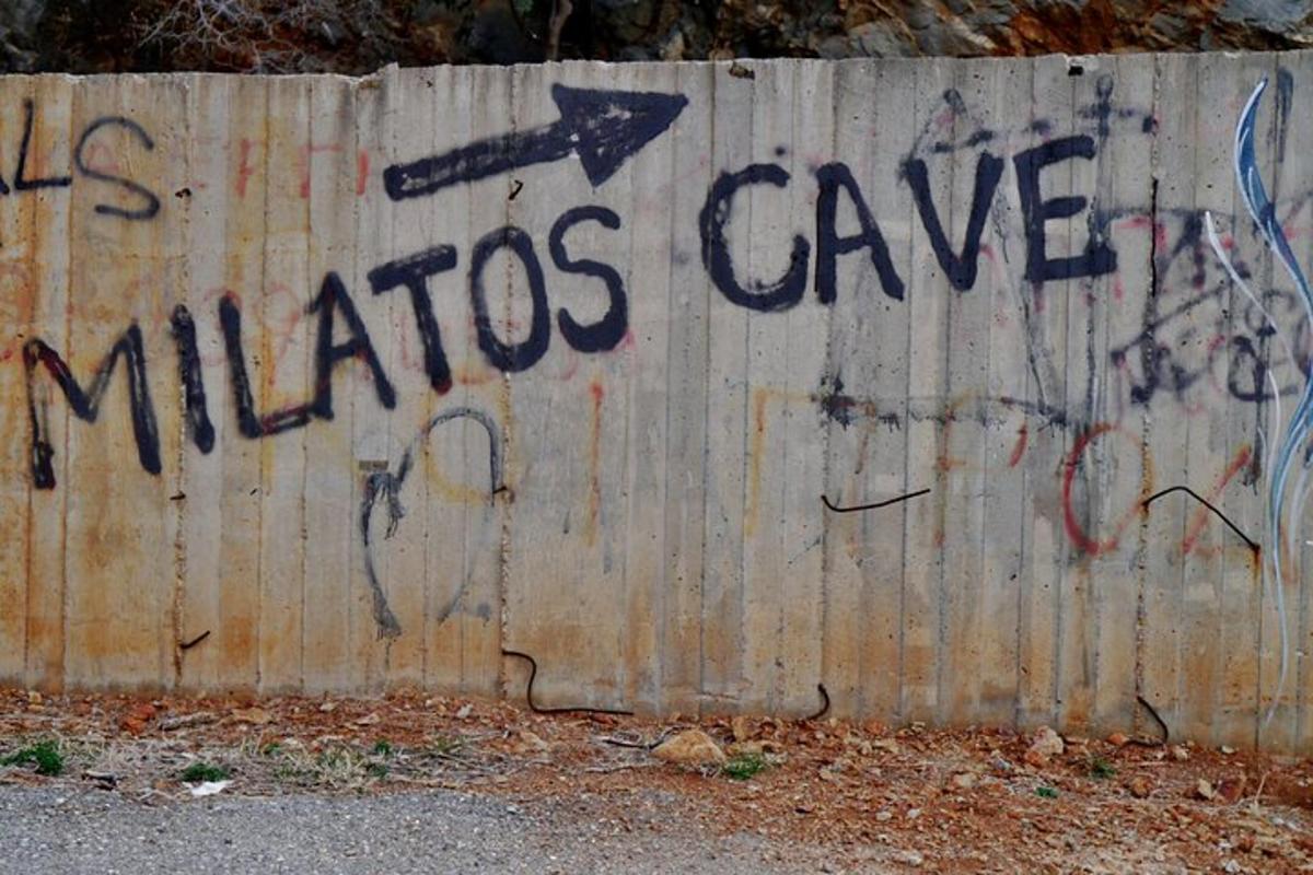 un muro con un cartello che dice grotta di Milos