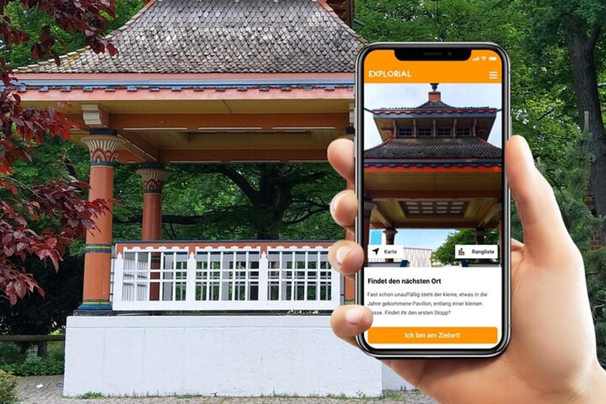 a person holding up a cell phone in front of a building