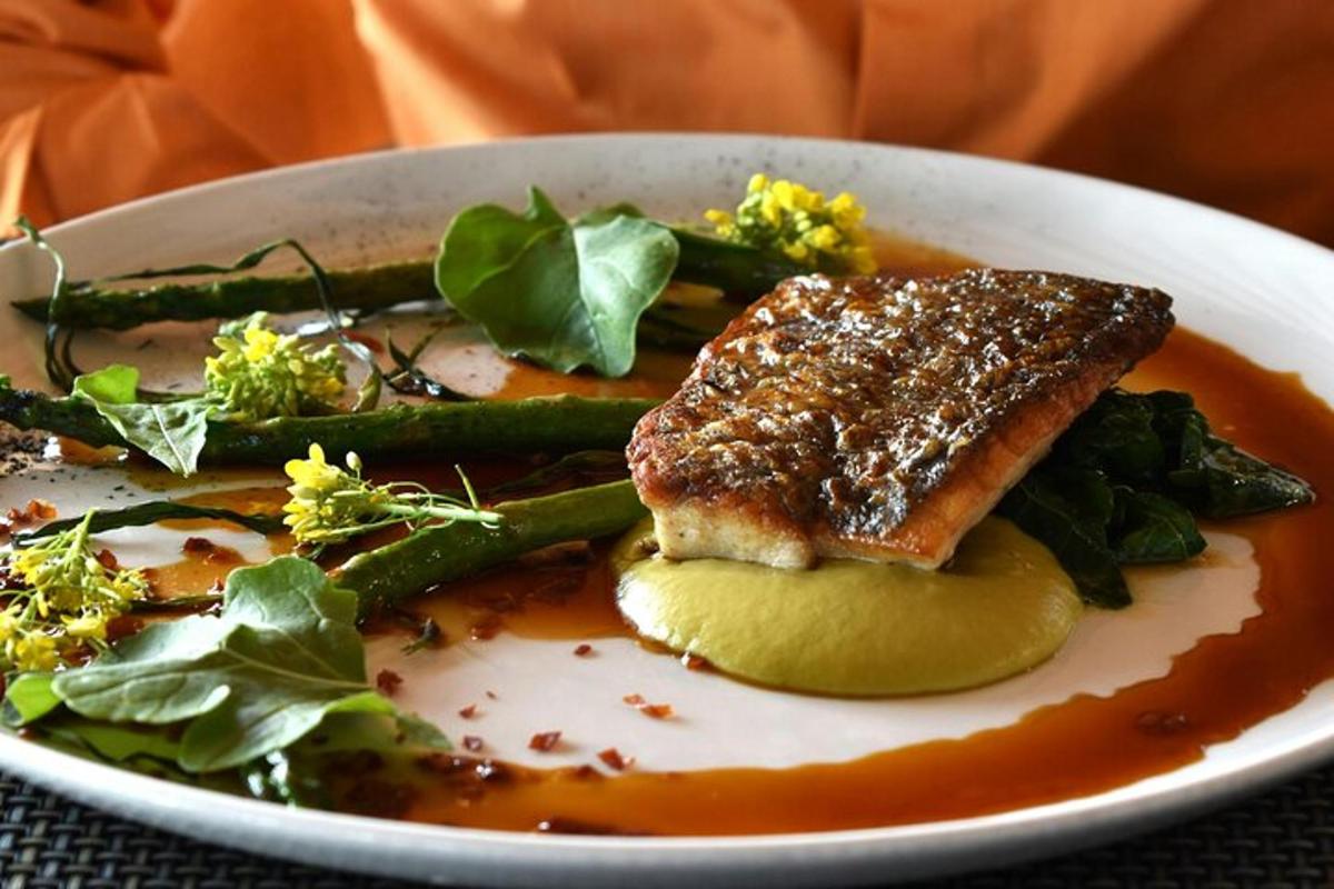 a plate of food with a piece of fish and asparagus